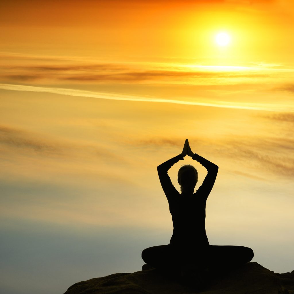 Woman meditating at sunrise | Wych Elm Reiki and Intuitive Services